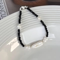Dettaglio del bracciale con perle barocche e spinello nero su un piatto di ceramica - Stile Perline Nere Con Perla Barocca (23790B)