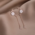 Detalle de pendientes de flor con cadenas de oro rosa y colgantes de circón en gota - Dorado