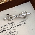 Polished silver metal bow hair clip with minimalist ribbon design on canvas tray - Bowknot Hair Clip (23778) / Silver