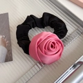 Détail d'un chouchou rose en satin en forme de rose sur un plateau argenté de style français - Rouge Rose