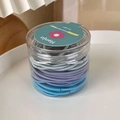 Primo piano di elastici per capelli blu e viola conservati in un barattolo cilindrico trasparente - Blu Sfumato (23969G)