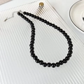 Primer plano del collar de cuentas de vidrio negras con cierre de mosquetón plateado - Estilo 8mm (24031C)