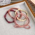 Detailaufnahme von herbstlichen elastischen Haargummis und Schleifen auf einem Tablett - 24076A Pastellrosa