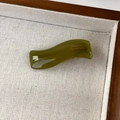 Detailed close-up of dark olive green wavy acetate hair clip with gold France Handmade text - Seaweed Green