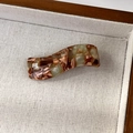 Detail of wave-shaped acetate hair clip with marble green pattern and gold handmade text - Brown White Colorful