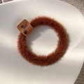 Close-up of brown plush hair tie with butterfly label on a white minimalist tray - Brown Coffee