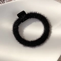 Close-up of a plush black elastic hair tie with a square bead detail in a ceramic dish - Black