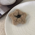 Detail einer khakifarbenen Plüsch-Stern-Haarspange auf einem weißen Keramiktablett - Kaffee Stern