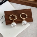 Detailopname van vintage barokke gouden oorringen met elegante witte parelhangers - Wit
