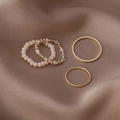 Detail of pink crystal beads and golden metal rings on a luxury brown satin fabric - A Pink / Pink
