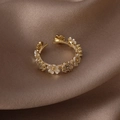 Anello regolabile in oro con fiori di conchiglia e zirconi su sfondo di seta - Oro