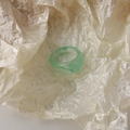 Close-up of a wide green resin ring with marble texture on white crinkled paper - Green Waterdrop