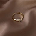 Close-up of gold adjustable ring with round brown zircon on brown silk background - Small Single Zircon Style (16341)