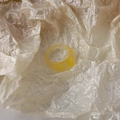 Close-up of yellow resin ring with white marble texture on pearl paper background - Yellow Water Drop Style