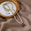 Detail der Perlenkette mit getrocknetem Rosenanhänger auf braunem Seidenstoff - Weiße Halskette / Weiß
