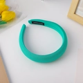 Close-up of mint green fabric headband with handmade label and soft texture finish - Green