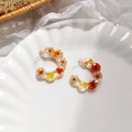 Detail of C-shaped resin earrings with colorful dried flowers on a white porcelain plate - Red Flower Style / Red