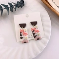 Detailed close-up of handmade clay floral earrings on a decorative ceramic plate - White Flower Style (A 白花朵)