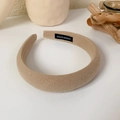 Detail view of khaki sponge headband with handmade label on soft fabric surface - Khaki