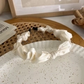 Detail of cream white pleated satin headband with silky texture and wave edge - Off White