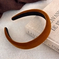 Gros plan d'un serre-tête en velours caramel avec rembourrage épais sur livre vintage - Velours Caramel (17882C)