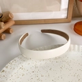 Primer plano de una diadema de cuero blanco crema con diseño acolchado en plato cerámico - Mediano / Blanco Crema