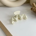 Vue macro d'une pince à cheveux mate blanc cassé avec une surface texturée ondulée - Style Vague (18061)