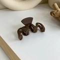 Gros plan d'une pince à cheveux mate marron foncé ondulée sur un fond blanc épuré - Style Vague (18063)