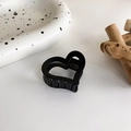Detail of matte black heart-shaped hair claw clip with sturdy teeth on a ceramic tray - Heart Shaped Style (5# 18080)