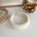 Dettaglio fascia per capelli in peluche crema con consistenza morbida per cura viso - Bianco