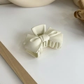 Dettaglio della pinza per capelli a fiocco in resina crema opaca su sfondo pulito - Stile Fiocco (18069) / Beige