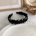 Detailed shot of black pleated headband with elegant white pearls on a ceramic plate - Black Pearl Pleated (17835B)