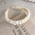 Detail of a beige satin ruched scrunchie headband on linen fabric with elegant textures - Scrunchie Satin Style (17848)