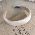 Detailed close-up of cream satin padded headband with hand-made label on linen book - Padded Satin Style (26526A)