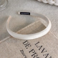 Close-up of beige satin wide headband featuring a black handmade woven label detail - Silky Satin Style (23922A)