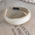 Detail of cream padded satin headband with handmade label on rustic fabric - Bright Satin Style (26806A)