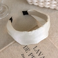 Close-up of beige satin wide pleated headband on vintage book showing fabric texture - Wide Pleated Satin Style (27281A)