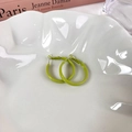 Nahaufnahme neongrüner Creolen auf einem weißen Dekoteller mit strukturierter Oberfläche - Kleiner Ring (E) / Grün