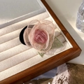 Detail van roze organza roos haarelastiekje met groene geborduurde bladeren op hout - Haarelastiek Stijl (20681B)