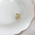 Close-up of S925 gold plated double layer crossover ring with zircons on ceramic tray - Zirconia Cross Style / Gold