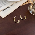Detalle de pendientes de botón chapados en oro con diseño en C sobre madera oscura - Estilo Forma C de Doble Línea Oro Mate (D 双管水滴)