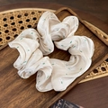 Close-up of floral satin scrunchie with cream puff fabric on vintage wooden tray - Apricot