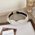 Detalle de diadema trenzada de tela crema en marco de madera con estilo vintage - Beige