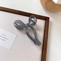 Detalle de una pinza para el pelo con lazo gris translúcido en soporte texturizado - Gris Gelatina