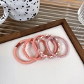 Detailed view of 5-piece pink elastic hair ties with braided and smooth textures - Orange Pink