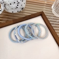 Set of 5 braided elastic hair ties in pastel blue and cream tones on wood display - Blue