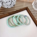 Detailed set of 5 pastel braided elastic hair ties displayed on a minimalist wooden tray - Green