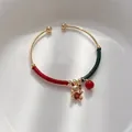 Gouden open armband met rood-groene draadwikkeling en gelukskat hanger detail - Gouden Gelukskat (Hoofdstijl)