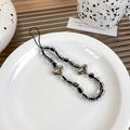 Close-up of black and white square beaded phone strap with metallic silver hearts decoration - Silver Heart (21832)