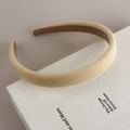 Primer plano de diadema de terciopelo beige sobre un libro con suave iluminación estética - Beige